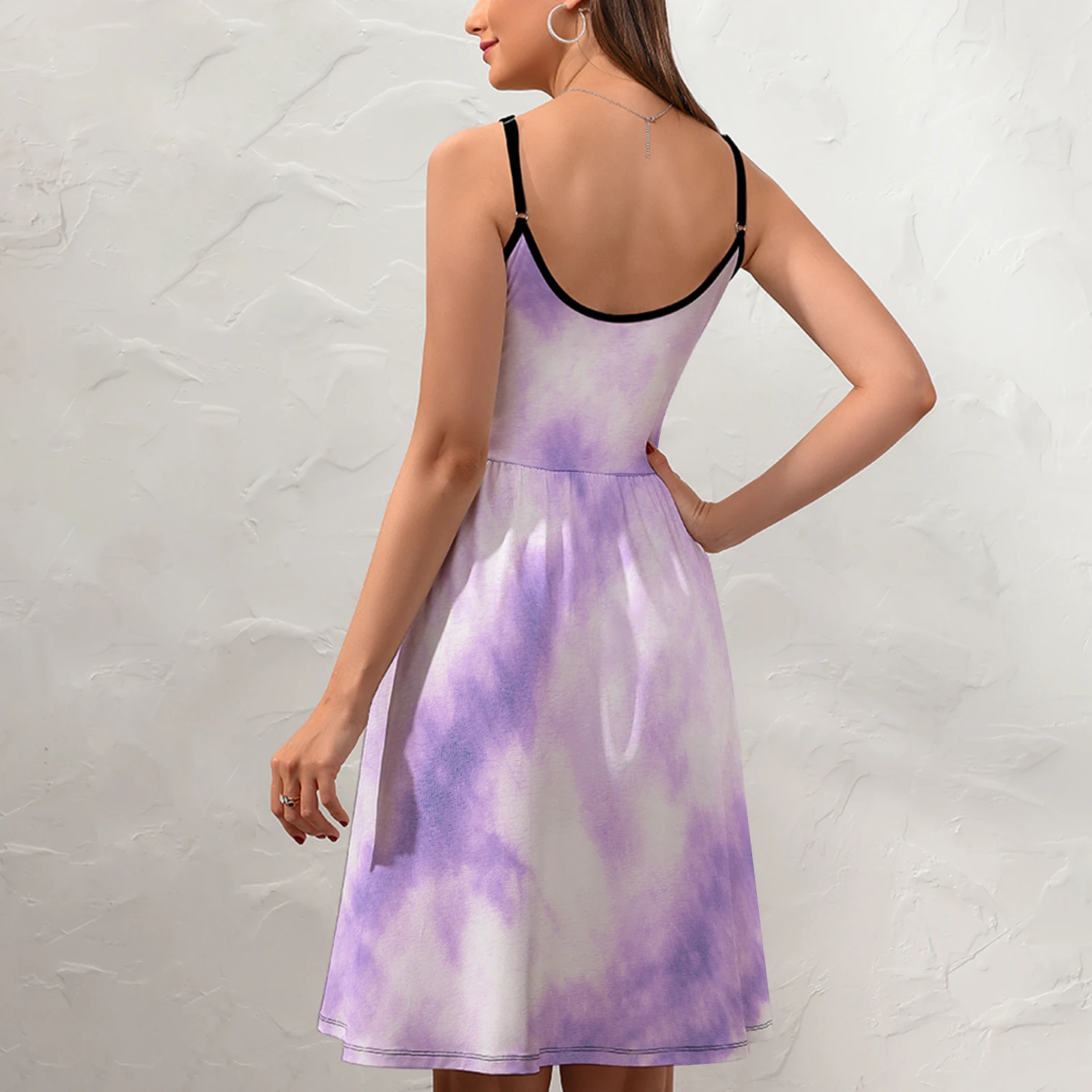 Women's V-Neck Cami Skater Dress in Lavender Tie-Dye print – back three-quarter view on model against a textured wall