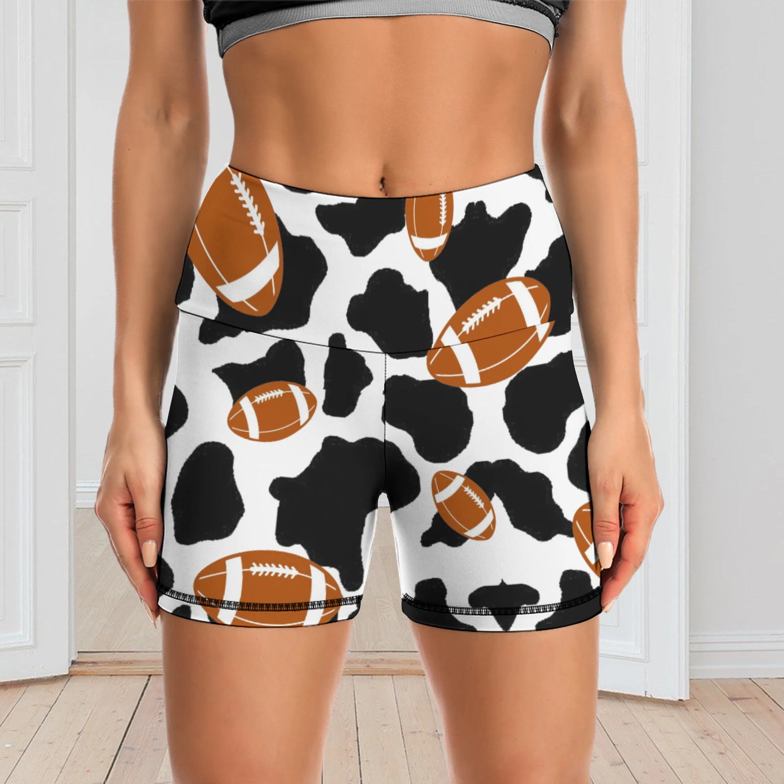 Women's High-Waist Yoga Shorts in Footballs And Cow Spots print – front view indoors